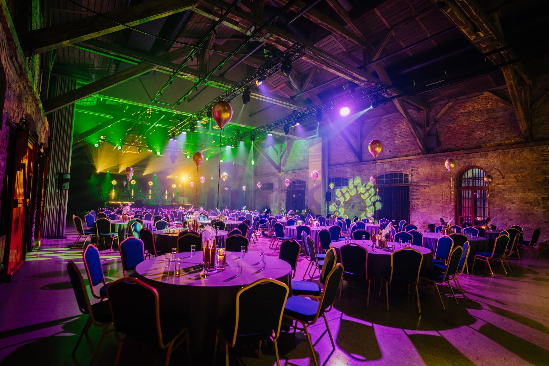 Corporate event venue with professional stage lighting and table setup
